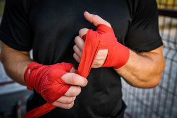 the athlete wraps his hands with a bandage before the fight in Boxing