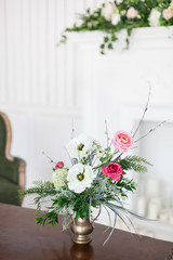 A bouquet of artificial flowers in a vase in the luxurious interior of the room. Soft focus.