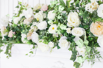 Decoration of the fireplace with flowers in a bright interior. close up. Soft focus.