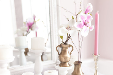 Delicate and light decoration of the dressing table with flowers, candles. Soft focus. Close up.