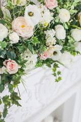 Decoration of the fireplace with flowers in a bright interior. close up. Soft focus.