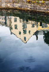 reflection of an old house in canal water