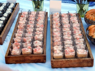 catering banquet table with different food snacks and appetizers in glass on corporate event, christmas, birthday, wedding celebration. Catering, banquet, buffet or party food concept. salmon in glas