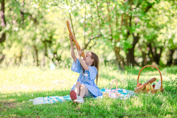 Little kid with big bread on picnic in the park
