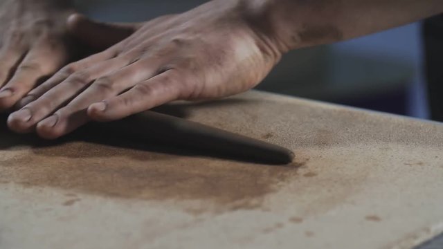 Potter rolls clay. Man hands making clay product. Potter's work close-up. Step by step