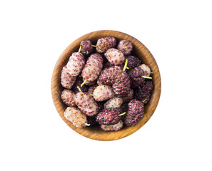 Mulberries on wooden bowl with copy space for text. Black and purple mulberry on white background. Ripe and tasty mulberry isolated on white background. Top view.