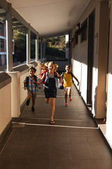 Schoolkids with schoolbags running in hallway