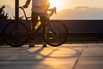 Fototapeta na wymiar a man ride a bicycle at sunset with sunbeam over Urban landscape, road