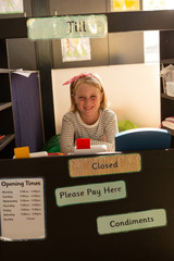 Schoolgirl pretending to be an executive at bill counter