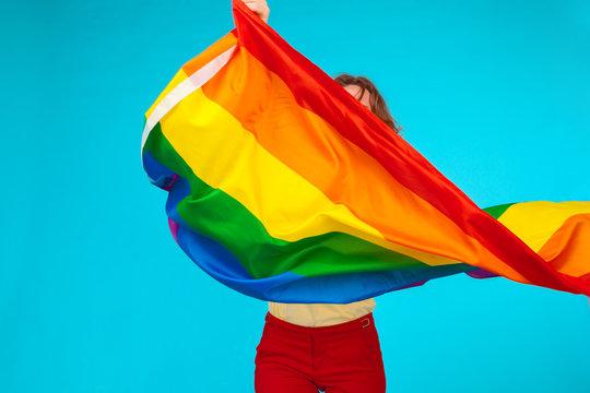 Rainbow flag. Woman holding and waving large LGBT flag