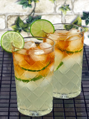 Dark'n Stormy Cocktails made with dark rum and ginger beer, decorated with lime slices   