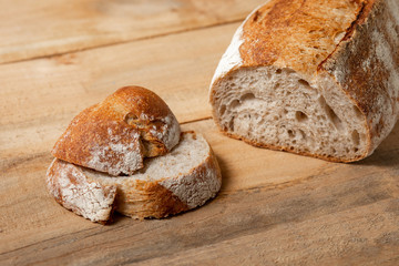 Fresh bread slices on a wooden table. View from above