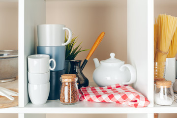 Fototapeta na wymiar Utensils and mugs, Kitchenware on wooden shelves