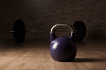 Naklejka na ściany i meble kettle bell and weight lifting bar on a wooden floor gym.