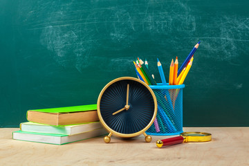 School supplies. Writing utensils and alarm clock. Time to study concept