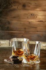 Two glasses of bourbon or scotch, or brandy and pieces of dark chocolate