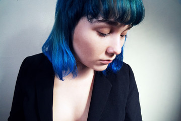 Portrait of a young woman with blue hair in a jacket.