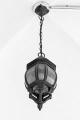 black vintage lamp hangs on a chain under a vaulted ceiling. black and white photo