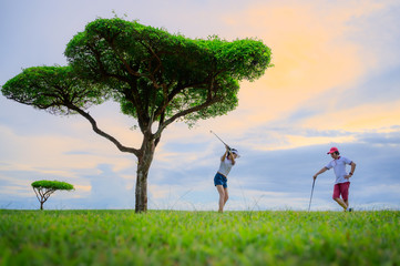 couple lover golf player enjoy together playing hit golf ball in the fairway in safari green golf...