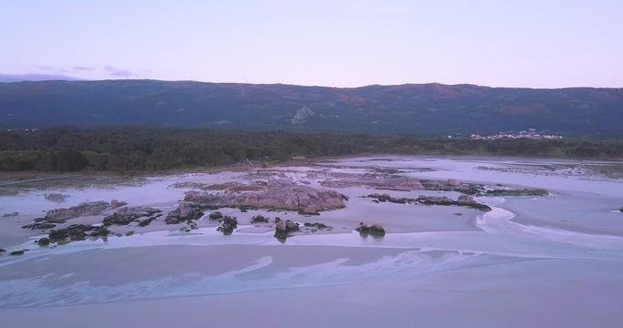 Sunset at a stunning Galician beach with a river estuary and a forest nearby n7