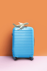 Suitcase and airplane model, minimal creative travel concept.