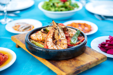 Shrimp, Seafoods, appetizers and salads on the table in Fish Restaurant. Beach Restaurant in Greece or Turkey. Aegean seaside, Greek or Turkish style fish restaurant in Bodrum, Santorini or Mykonos