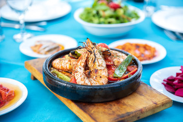 Shrimp, Seafoods, appetizers and salads on the table in Fish Restaurant. Beach Restaurant in Greece or Turkey. Aegean seaside, Greek or Turkish style fish restaurant in Bodrum, Santorini or Mykonos