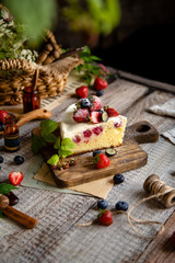 Homemade delicious slice of raspberry biscuit cake with white cream, strawberries, blueberries