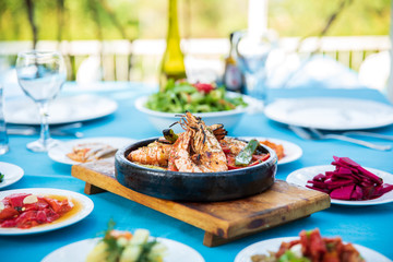 Shrimp, Seafoods, appetizers and salads on the table in Fish Restaurant. Beach Restaurant in Greece or Turkey. Aegean seaside, Greek or Turkish style fish restaurant in Bodrum, Santorini or Mykonos