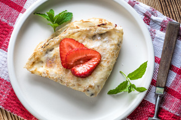 Polish pancakes with jam, cheese and strawberries.