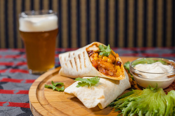 Breakfast on a plate with herbs and wrapped vegetables in bread and light beer