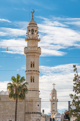 Muslim minaret and christian church at background in Bethlehem, Palestine.