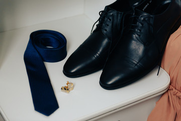 shoes, tie and cufflinks on a light background