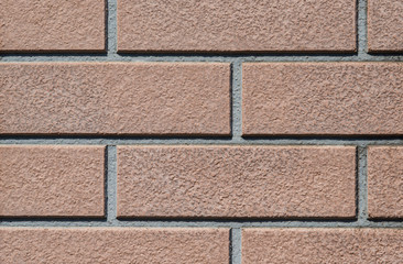 Brown rectangular tiles wall with rough surface as background