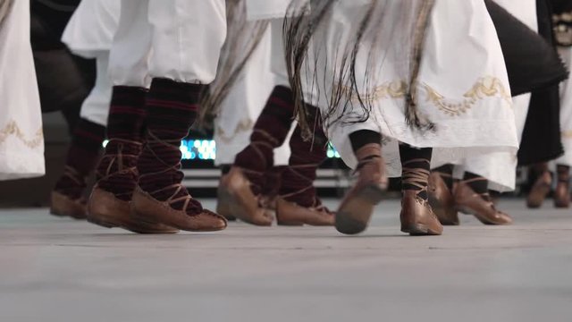Traditional romanian folklore dancers in traditional costumes dancing on stage in slow motion