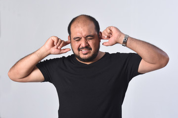 latin american man making noise hurting her ears on white background