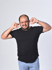 latin american man making noise hurting her ears on white background