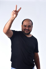 Latin american man making the victory sign on a white background