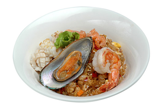 Seafood pilaf in a white plate on a white isolated background. View from above