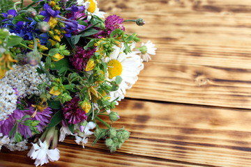 Fototapeta na wymiar Bouquet of wild flowers on wooden background
