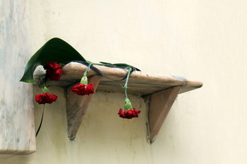 four flowers laid on the wall of the house in honor of the memory of the man who lived there