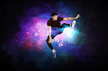 Naklejka na ściany i meble Modern dancer jumping with colourful splashes background. Mixed media