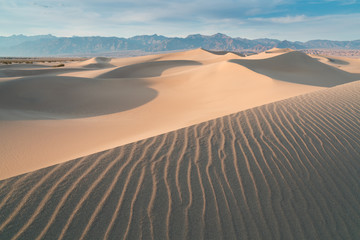 Early Morning Sunlight Over Sand Dunes And Mountains At Mesquite flat dunes, Death Valley National Park, California USA Stovepipe Wells sand dunes, very nice structures in sand Beautiful background