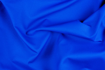 Bright blue fabric texture with folds.