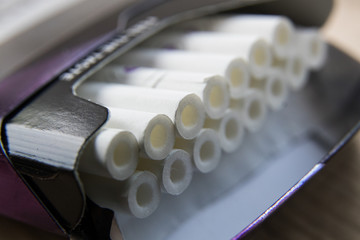 thin cigarette on a gray wooden board, macro shot