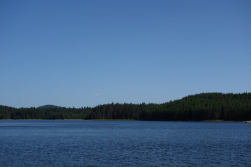 View of the landscape of the lake  in the mountain during summer. Copy space for text on blue sky.