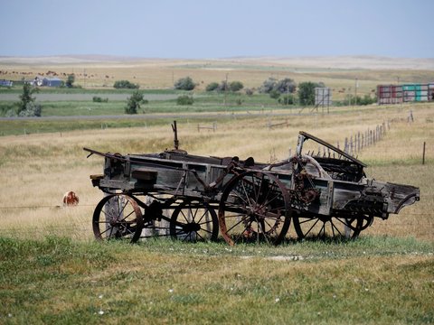 Dilapidated wooden wagon cart displayed in a farmland outside an 1880s town in South Dakota.