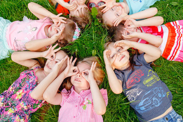 A group of happy children of boys and girls run in the Park on the grass on a Sunny summer day ....