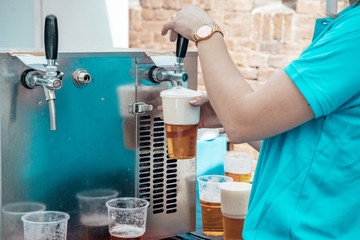 rotating beer at outdoor event in plastic cups. From a mobile dispensing equipment. Catering