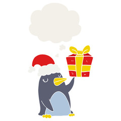 cartoon penguin with christmas present and thought bubble in retro style